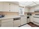Cozy kitchen with white cabinetry, floral wallpaper, and stainless steel appliances at 2462 Kingfisher Ln # J203, Clearwater, FL 33762