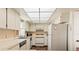 Charming kitchen featuring white cabinetry, stainless steel appliances, and tile flooring at 2462 Kingfisher Ln # J203, Clearwater, FL 33762