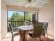 A tiled patio featuring a table and chairs, screened for privacy, and a view of foliage at 2462 Kingfisher Ln # J203, Clearwater, FL 33762