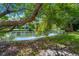Scenic view of the pond with mature trees and reflections of the buildings at 2462 Kingfisher Ln # J203, Clearwater, FL 33762