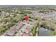 Overhead view of a residential neighborhood with mature trees, pond and the home is marked by a pin at 25325 Welsh Poppy Way, Land O Lakes, FL 34639