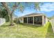 Private backyard features a screened lanai, lush lawn, mature tree, and white fence at 25325 Welsh Poppy Way, Land O Lakes, FL 34639
