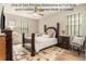 Cozy bedroom featuring a large bed and nightstands, wood floors, and a neutral rug at 25325 Welsh Poppy Way, Land O Lakes, FL 34639