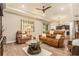 Comfortable living room with hardwood floors, a ceiling fan and an open view of the kitchen at 25325 Welsh Poppy Way, Land O Lakes, FL 34639
