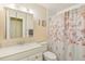 Bathroom with granite vanity, mirror, toilet, and shower with floral curtain at 2717 Warwick Ter, Palm Harbor, FL 34685