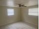 Bright bedroom with a ceiling fan and two windows at 3641 Dickens Dr, Holiday, FL 34691