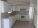 White kitchen featuring matching appliances, a stainless steel sink, and tile floors at 3641 Dickens Dr, Holiday, FL 34691