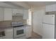 A kitchen with white cabinets, white appliances, and tile floors at 3641 Dickens Dr, Holiday, FL 34691