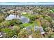 Aerial view capturing a lake in a residential area with large lots, mature trees and homes at 3944 Sprucewood Pl, Land O Lakes, FL 34639