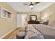 Comfortable bedroom featuring a ceiling fan, hardwood floors, and a stylish accent wall decor at 3944 Sprucewood Pl, Land O Lakes, FL 34639