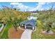 Inviting home with well-maintained landscaping and water view, complemented by a concrete driveway and gray garage door at 3944 Sprucewood Pl, Land O Lakes, FL 34639