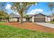 Charming single story home featuring a well-manicured lawn, mature trees, and attached two car garage at 3944 Sprucewood Pl, Land O Lakes, FL 34639