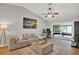 Bright living room featuring vaulted ceiling, neutral palette, modern decor, and view of screened porch at 3944 Sprucewood Pl, Land O Lakes, FL 34639