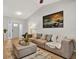 Inviting living room featuring neutral walls, plank flooring, a cozy sofa, and a striking coastal art piece at 3944 Sprucewood Pl, Land O Lakes, FL 34639