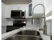 Close up of kitchen sink, stainless steel appliances, quartz countertops, and white cabinets at 4036 Cortez Dr # A, Tampa, FL 33614