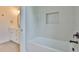 Well-lit bathroom with a bathtub, gray tiled walls, niche, and modern black hardware, offering a relaxing space at 418 W Frances Ave # 1, Tampa, FL 33602