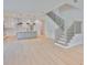 Open concept living area featuring hardwood floors, white cabinets, and a staircase at 418 W Frances Ave # 2, Tampa, FL 33602