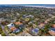 Aerial view of a quaint residential area with a mix of colorful houses and rich vegetation, water visible behind the city at 4610 W Lamb Ave, Tampa, FL 33629
