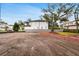 Residential lot with mature trees and neighborhood homes under a blue sky highlighting the potential for new construction at 4610 W Lamb Ave, Tampa, FL 33629