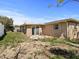 Exterior rear view with a sliding door, backyard with partial patio at 5117 School Rd, New Port Richey, FL 34653