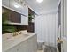 Compact bathroom with a vanity, sink, and shower-tub combo with a curtain at 5117 School Rd, New Port Richey, FL 34653