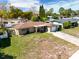 Single story home with a front yard, driveway, neutral color scheme, and an attached one car garage at 5117 School Rd, New Port Richey, FL 34653