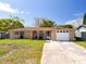 Charming single-story home featuring a large driveway, a one-car garage, and a well-maintained lawn at 5117 School Rd, New Port Richey, FL 34653