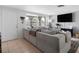 Bright living room with a large sectional sofa, neutral decor, and tiled flooring at 5117 School Rd, New Port Richey, FL 34653
