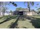 Spacious backyard with grass, screened-in porch, and a white fence at 5155 Kenmore St, Spring Hill, FL 34608