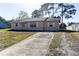 Exterior view of home with a concrete driveway and a well maintained lawn at 5155 Kenmore St, Spring Hill, FL 34608