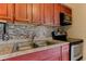 Close up on the kitchen with double stainless sink and a mosaic tile backsplash at 5155 Kenmore St, Spring Hill, FL 34608