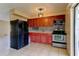 Traditional kitchen featuring wood cabinets, stainless steel appliances, neutral countertops and tiled floors at 5155 Kenmore St, Spring Hill, FL 34608