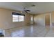 Bright and airy living room with tile flooring, ceiling fan, and a view of the front yard at 5155 Kenmore St, Spring Hill, FL 34608
