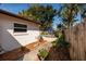 Private backyard with pool area, patio seating, and wooden fence surrounded by lush landscaping at 5611 Venetian Ne Blvd, St Petersburg, FL 33703