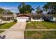 Charming single-story home featuring a well-maintained lawn, attached garage, and an inviting entrance at 5611 Venetian Ne Blvd, St Petersburg, FL 33703
