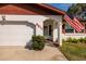 Close up of a charming white home with a two-car garage, address numbers, and neat landscaping at 5611 Venetian Ne Blvd, St Petersburg, FL 33703