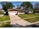 View of the front of the house, showcasing the driveway, lawn, front door, and garage at 5611 Venetian Ne Blvd, St Petersburg, FL 33703