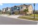 Street view of townhomes featuring colorful facades and well-maintained landscaping on a sunny day at 5786 Spotted Harrier Way, Lithia, FL 33547