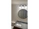This bathroom has a granite countertop, a round mirror, and modern lighting at 6011 Skydale Way # 101, Riverview, FL 33578