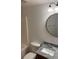 Bathroom featuring a granite countertop, a round mirror, and modern lighting at 6011 Skydale Way # 101, Riverview, FL 33578