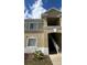 Beige two-story condo building exterior featuring a stairwell entrance and sunny skies above at 6011 Skydale Way # 101, Riverview, FL 33578
