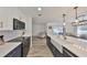 Modern kitchen boasts stainless appliances, white countertops, dark cabinetry, and an island with a farmhouse sink at 6333 Spanish Main Dr, Apollo Beach, FL 33572