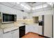 Kitchen featuring white cabinets, countertops, appliances, and hardwood flooring at 6960 20Th N Ave # 405, St Petersburg, FL 33710