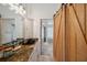 Bathroom featuring a granite countertop, black sink, and wooden sliding door to the walk-in closet at 716 Samantha Dr, Palm Harbor, FL 34683