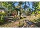 Lush back yard featuring a garden, a stone bench, walkway and mature trees at 912 E 23Rd Ave, Tampa, FL 33605