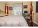 Well-lit bedroom with a bed, desk, and door to the backyard offers both comfort and functionality at 912 E 23Rd Ave, Tampa, FL 33605