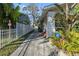 Charming home featuring a secure white fence, a concrete walkway and lush tropical landscaping at 912 E 23Rd Ave, Tampa, FL 33605