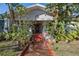 Charming home entrance with lush tropical landscaping, terracotta tile walkway, and unique architectural details at 912 E 23Rd Ave, Tampa, FL 33605