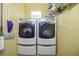 Bright laundry room featuring a modern, front-load washer and dryer set and storage shelves at 912 E 23Rd Ave, Tampa, FL 33605