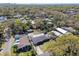 An aerial view shows a flat roofed home surrounded by lush greenery in a mature neighborhood setting with scattered homes at 200 W Louisiana Ave, Tampa, FL 33603